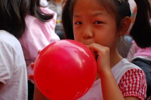 image of a child blowing up a balloon